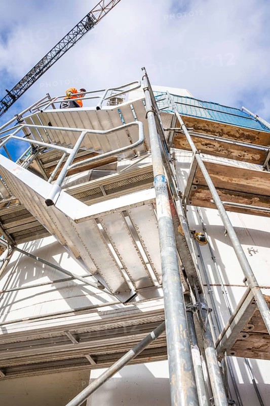 Close-up of a construction site with stairs and workers in front of a blue sky, extension of the Calw railway station for the new track of the Hermann Hessebahn, Calw, Black Forest, Germany