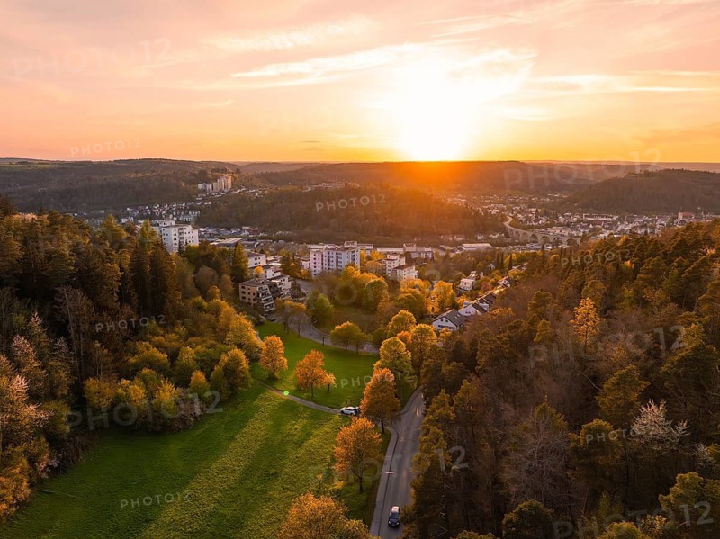 Aerial view of a cityscape at sunset, trees and buildings in the foreground, Nagold, district of Calw, Germany