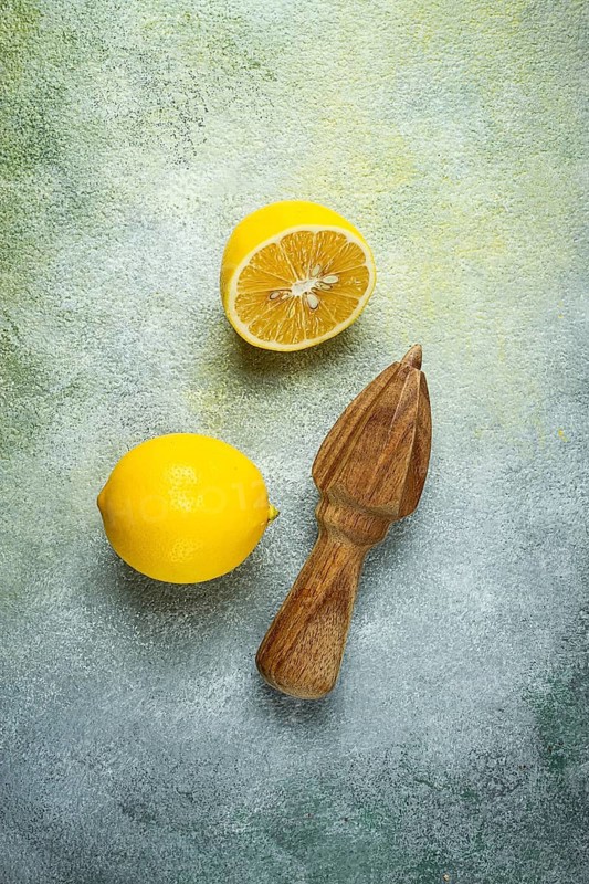 Wooden citrus reamer, manual lemon juicer, made of acacia wood, with citrus fruits on the table, top view