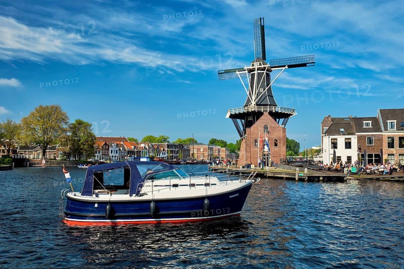 HAARLEM, NETHERLANDS, MAY 6, 2017: Harlem cityscape with windmill De Adriaan on Spaarne river. Haarlem, Netherlands