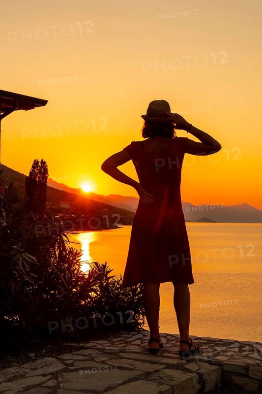 Silhouette of a woman at sunset at Shkoder lake in Shiroka municipality, summer vacation. Albania