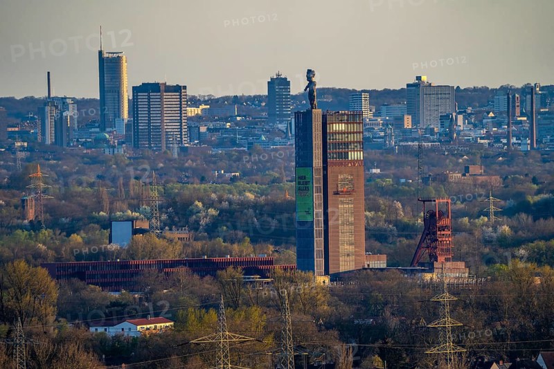 View over the Ruhr area from Gelsenkirchen in south direction to Essen, in front the Nordsternpark, next to it poster with new RVR slogan, Here everything remains different, former Nordstern colliery, behind it the skyline of Essen, North Rhine-Westphalia, Germany