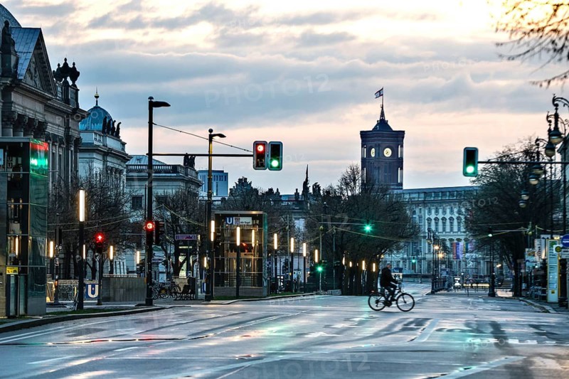 A cyclist rides along the empty boulevard Unter den Linden in the early morning, with a view of the Rotes Rathaus, Berlin, 26 January 2025, Berlin, Berlin, Germany