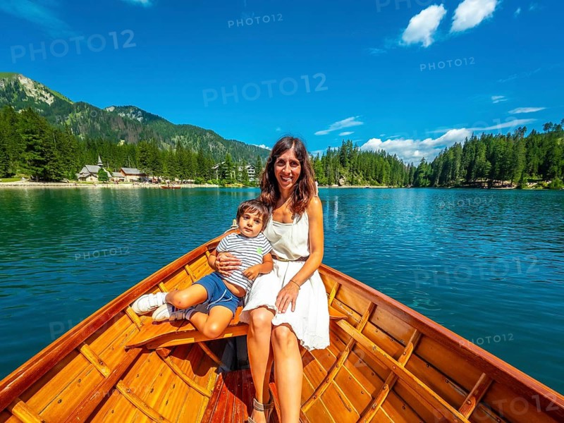 Tourists enjoying a relaxing boat trip on the beautiful lake braies, surrounded by the stunning scenery of the dolomites