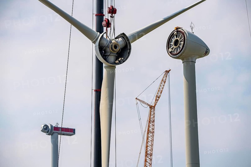 Dismantling of a wind power plant in a wind farm near Issum, 9 older wind turbines from the manufacturer Enercon (model series E-58), front, blades being dismantled, were in operation for over two decades, will be replaced by a total of four Enercon E-160 turbines, rear, assembly of the first blade, with a total output of 22 megawatts, Lower Rhine, North Rhine-Westphalia, Germany