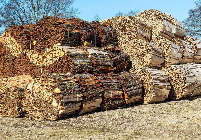 Bundles of wood offcuts and bark at a willow sawmill, Suffolk, England, UK