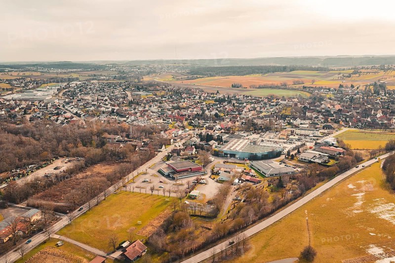 View of a town with mixed development and nearby commercial area, surrounded by open countryside, Ötisheim, Enzkreis, Germany