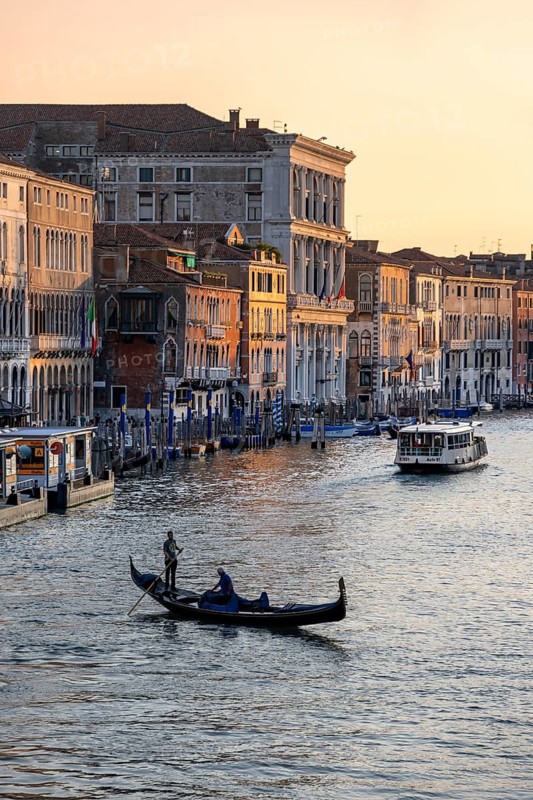 View of the Grand Canal with gondoliers at sunset, picturesque evening mood with palazzos on the canal, view from the Rialto Bridge, Venice, Veneto, Italy