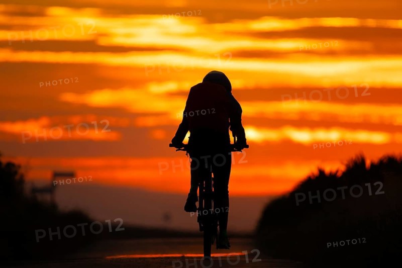 A cyclist rides towards the sunrise, Frankfurt am Main, Hesse, Germany