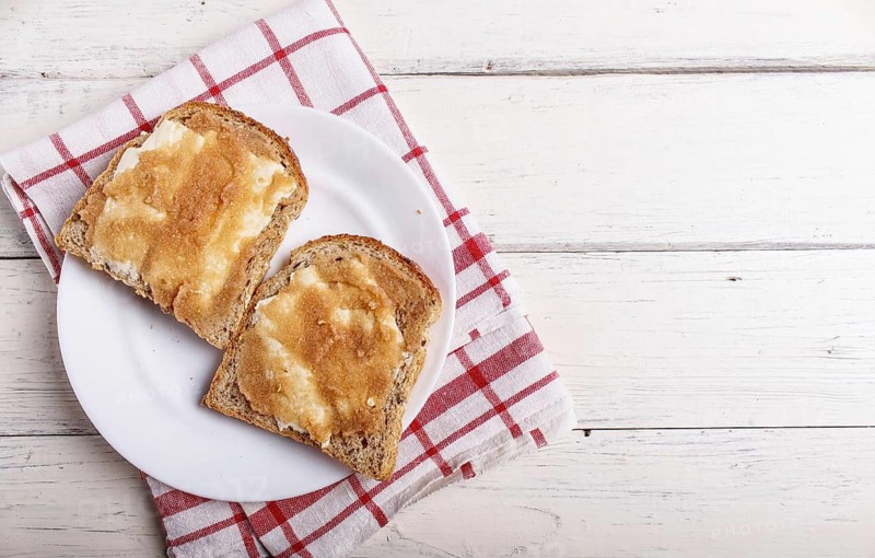 Sandwiches with pollock roe on a white plate, on a white wooden background with copy space, top view