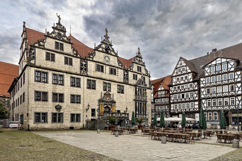 Historic market square with half-timbered houses and ornate buildings under a cloudy sky, The historic town hall of Hannoversch Münden in Lower Saxony