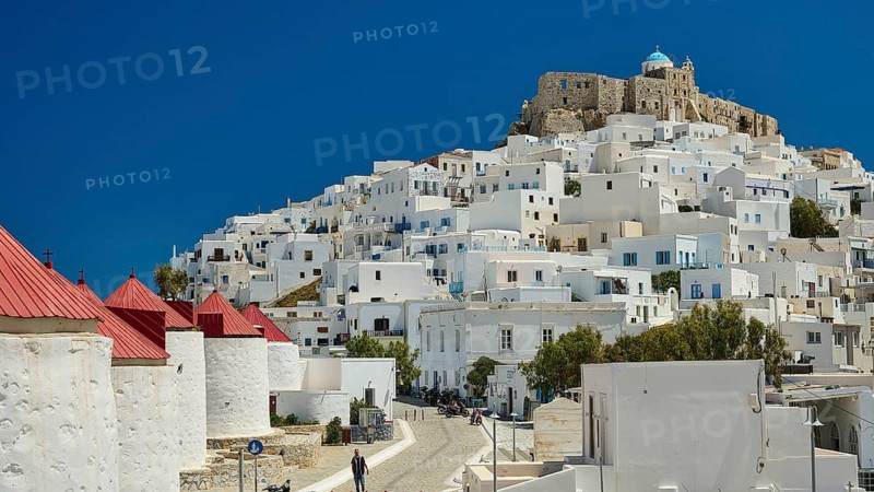 View of a compact settlement with white buildings under a clear, bright blue sky, windmills, Querini Castle, Chora, Astypalea, Dodecanese, Greek Islands, Greece