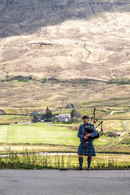 Piper over Mountains and Loch Tulla and River Orchy, Highlands, Scotland, UK