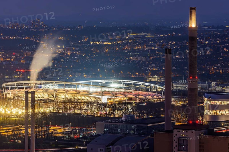 MHPArena, venue of the Bundesliga team VfB Stuttgart. The stadium is brightly lit during an evening match. On the right is the Mercedes Museum. Stuttgart, Baden-Württemberg, Germany