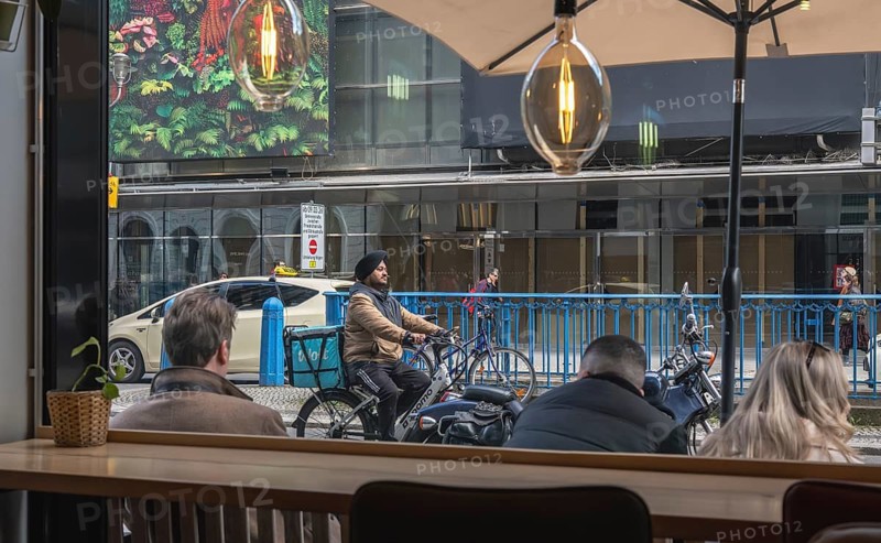 View through the window of a café of passers-by on Friedrichstraße in Mitte, Berlin, Germany