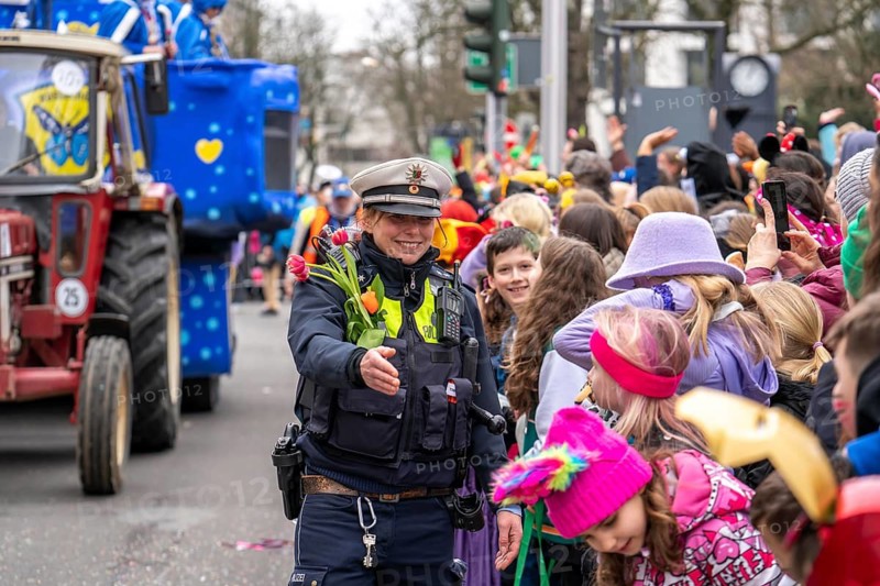 Rose Monday parade in Düsseldorf, policemen on duty at the street carnival, with flower decorations, given by the parade participants, North Rhine-Westphalia, Germany