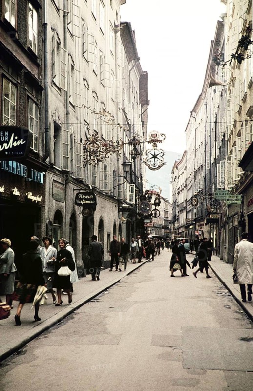 People shopping city centre alleyway of Getreidegasse, prominent guild sign for Wirtshausschild Sternbräu, Salzburg, Austria, Europe 1960