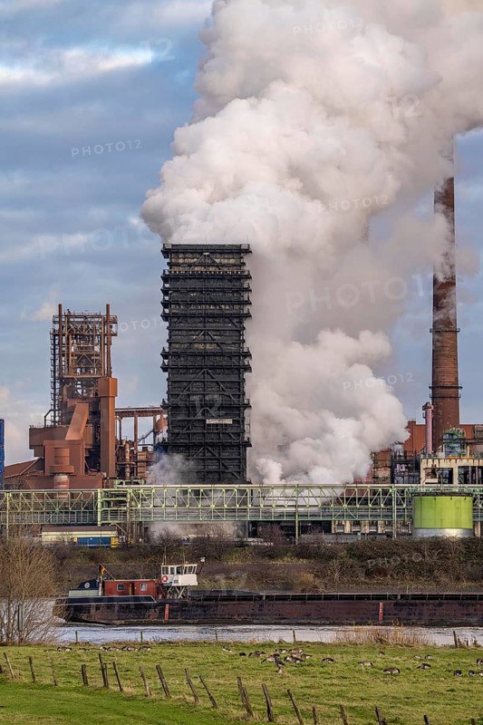 Industrial backdrop of the ThyssenKrupp Steel steelworks in Duisburg-Bruckhausen, on the Rhine, blast furnaces, Schwelgern coking plant, extinguishing cloud, Duisburg, North Rhine-Westphalia, Germany