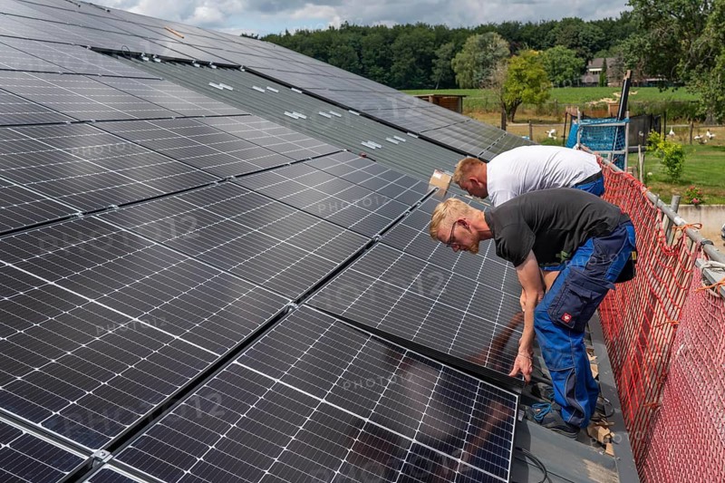 Installation of solar modules on the roof of a barn on a farm, over 210 photovoltaic modules are installed on the roof, North Rhine-Westphalia, Germany