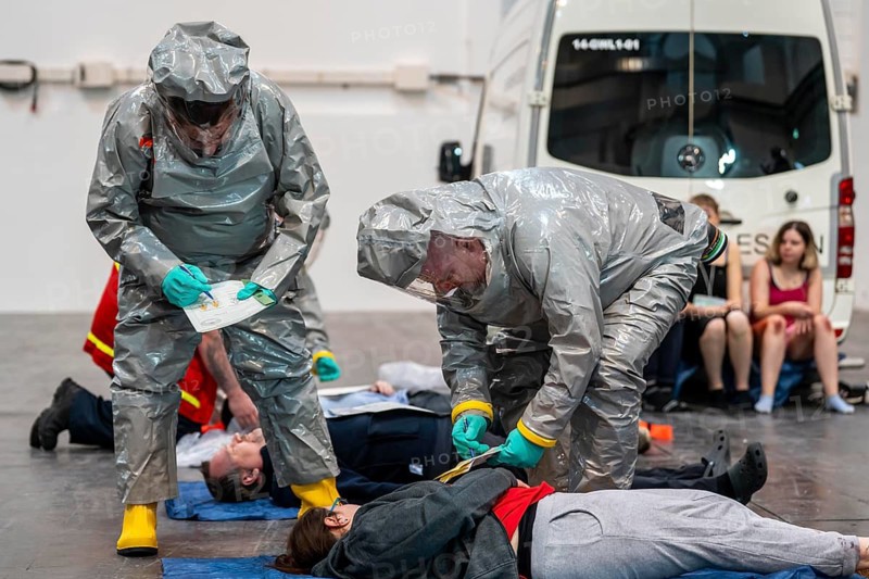 Viewing of patients in front of decontamination of injured persons after an assumed accident with hazardous substances, patient is intubated and ventilated by hand, fire brigade and aid organisations practise setting up and operating a decontamination station, injured persons are viewed and then washed in a special shower tent to remove possible hazardous substances and chemicals in order to avoid further injuries, the emergency services wear special, ventilated protective suits, large-scale exercise by the Essen fire brigade