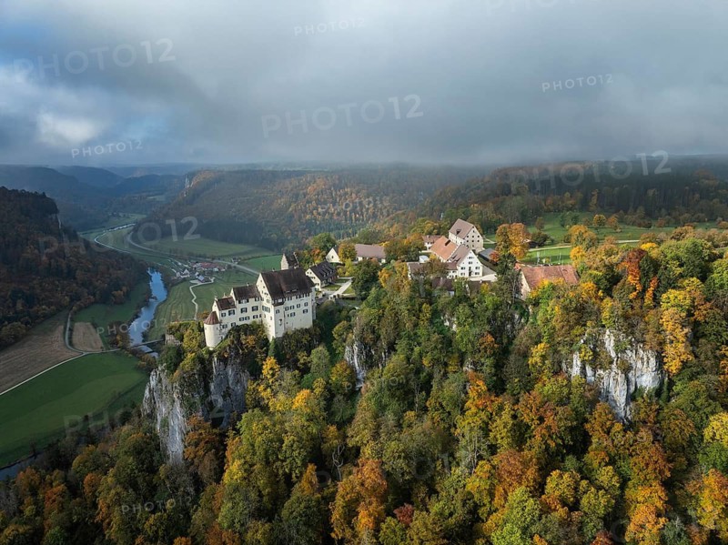 Aerial view of Werenwag Castle and former Werenwag Castle on a rocky spur in the Upper Danube Valley, surrounded by autumnal vegetation and clouds of fog, Sigmaringen district, Baden-Württemberg, Germany
