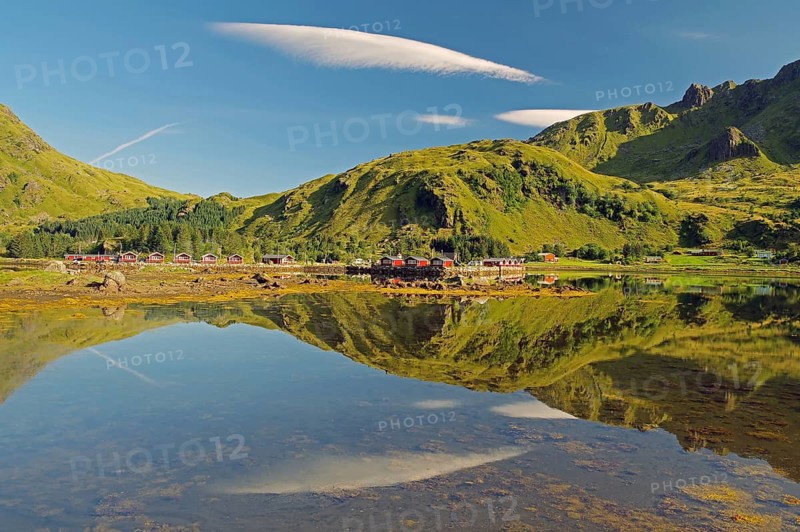 Wooden houses reflected in shallow fjord water, holiday cabins, Brustranda Sjøcamping, Valberg, Lofoten, Nordland, Norway