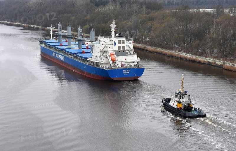 Cargo ship JNS SEA and tugboat travelling through the Kiel Canal in winter, NOK, Kielkanal, Kiel Canal, Schleswig-Holstein, Germany
