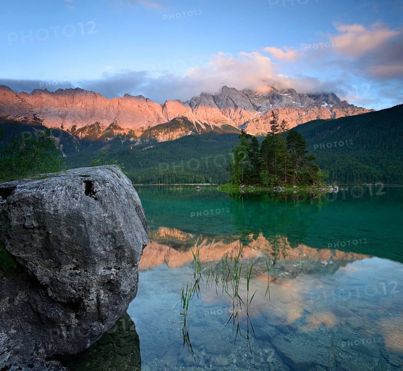Evening atmosphere and alpenglow at the Eibsee lake, in the background the Wetterstein mountains with the Zugspitze, clouds move over the peaks, Grainau, Garmisch-Partenkirchen, Bavaria, Germany