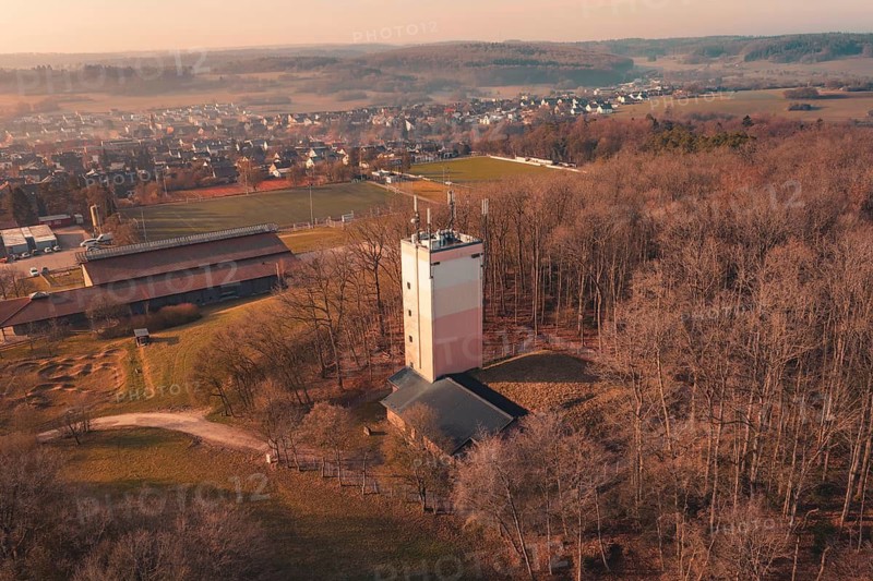 Wasserturm stands in a wooded area near a village, the picture is in yellow-orange tones, Gechingen, Calw district, Germany
