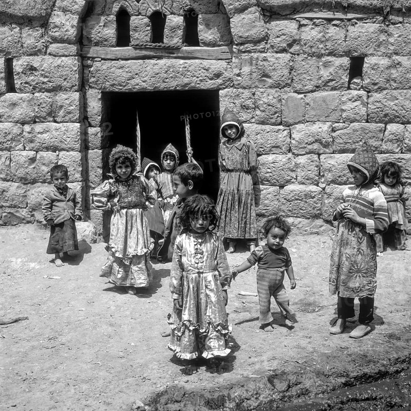 Children rocking in a house entrance, Amran, Yemen