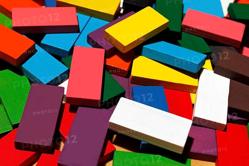 A collection of colorful wooden rectangular blocks scattered randomly. These vibrant geometric pieces are perfect for creative play, education, or interior decoration. Highlights the textures