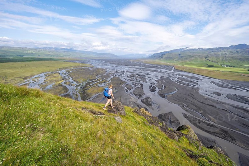 Hiker, Young woman on a hill, view over alluvial land, meandering river, Dímonarhellir, Suðurland, Iceland
