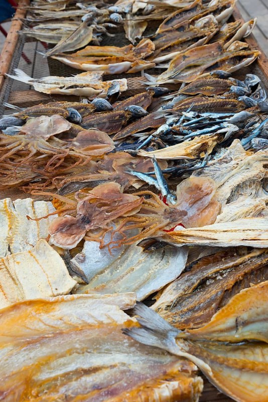 A wooden frame with various dried fish on the beach, fish drying, Praia da Nazare beach, Nazaré, Oeste, Leiria district, Centro, Portugal