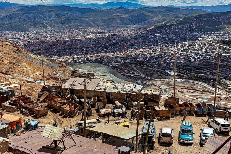 View of a collection of carts, buildings and vehicles with an urban landscape in the background, The Potosi Silver Mines on Cerro Rico in Bolivia
