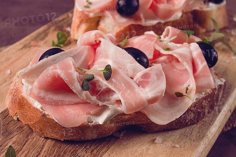 Breakfast, bacon and olives sandwich, on a cutting board, top view, close-up, no people