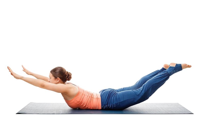 Woman doing Ashtanga Vinyasa Yoga asana Salabhasana A, locust pose A isolated on white background