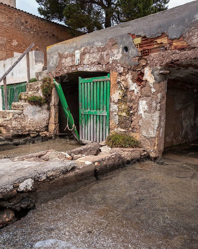 Old and dilapidated boat shelters that are not being used, old port area in Portocolom on the east coast of Majorca, Spain