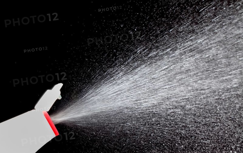A fine spray of glass cleaner against black background