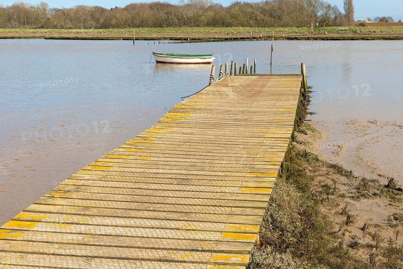Ferry boat at mooring and jetty of Butley River ferry, Suffolk, England, UK