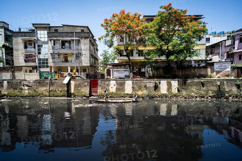 Ragpickers searching recyclable materials using a boat at a dirty polluted canal, in Guwahati, India on 28 May 2025