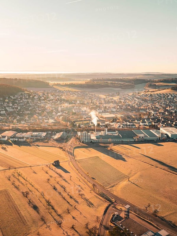 Town with neighbouring fields and industry in a hilly landscape seen from the air, Althengstett, district of Calw, Germany