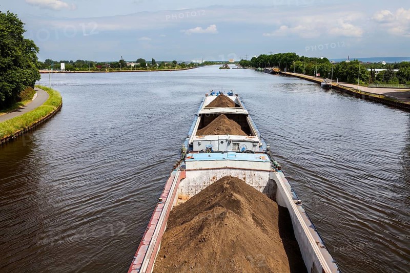 A towboat pushes a loaded barge in Minden, Mittelland Canal to Minden Aqueduct, Minden, North Rhine-Westphalia, Germany
