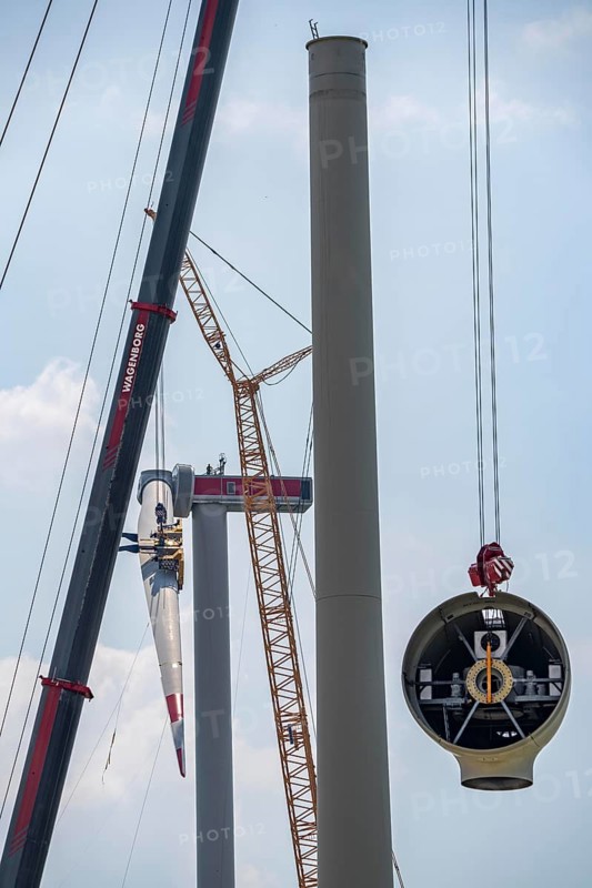 Erection of an Enercon E-160 wind turbine, rear, assembly of the first blade, 4 turbines with a total output of 22 megawatts replace 9 older wind turbines from the manufacturer Enercon (model series E-58) in the wind farm near Issum, front, dismantling of the nacelle, they were in operation for over two decades, Lower Rhine, North Rhine-Westphalia, Germany