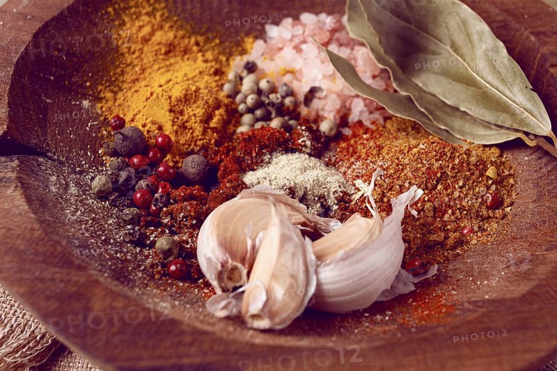Spice mix, garlic and bay leaf, on a wooden plate, close-up, food concept, no people