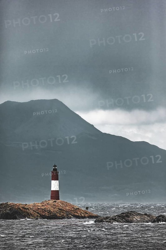 Lighthouse in a storm on a lonely rocky island in front of a mountain range, The lighthouse in the Beagle Channel near Ushuaia in Argentina