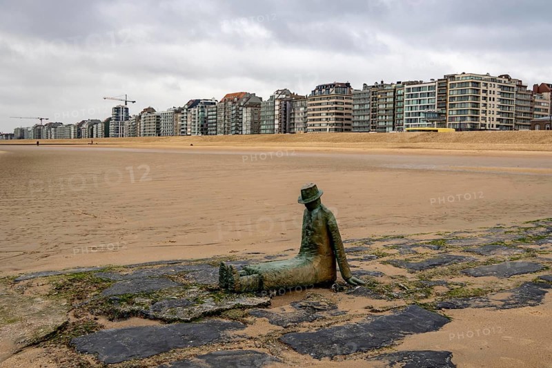 Art on the North Sea beach, in Knokke-Heist, La Mer, ce grand sculpteur, or The Sea, the Great Sculptor, by Jean-Michel Folon, is washed over by the sea at high tide, many permanent works of art in public spaces are spread around the city, here on the beach on the Zeedijk-Knokke, beach promenade, dreary winter day, Belgium
