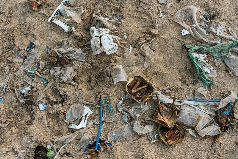 Debris on a beach in Bali signifies environmental pollution, showcasing the serious impact of waste on natural landscapes in Indonesia, urging conservation efforts