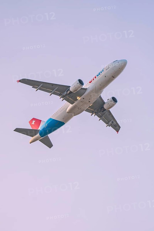 Close-up of a Swiss aircraft flying against the sky, Stuttgart Airport, Germany