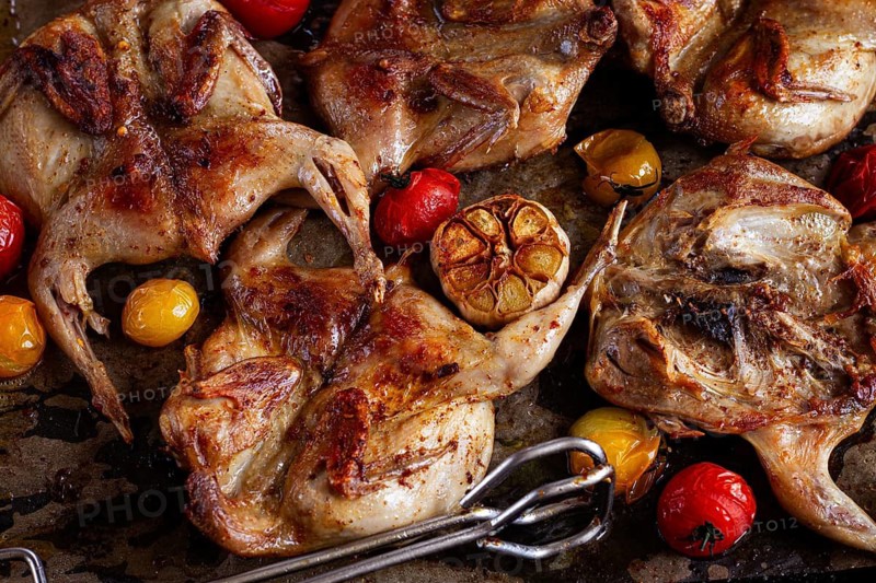 Grilled quail meat, on a platter, tobacco, in the oven, with spices, homemade, without people