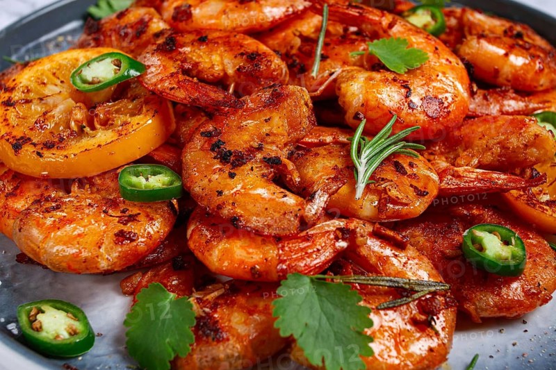 Grilled shrimp, unpeeled, headless, with spices, on a marble table, homemade, no people